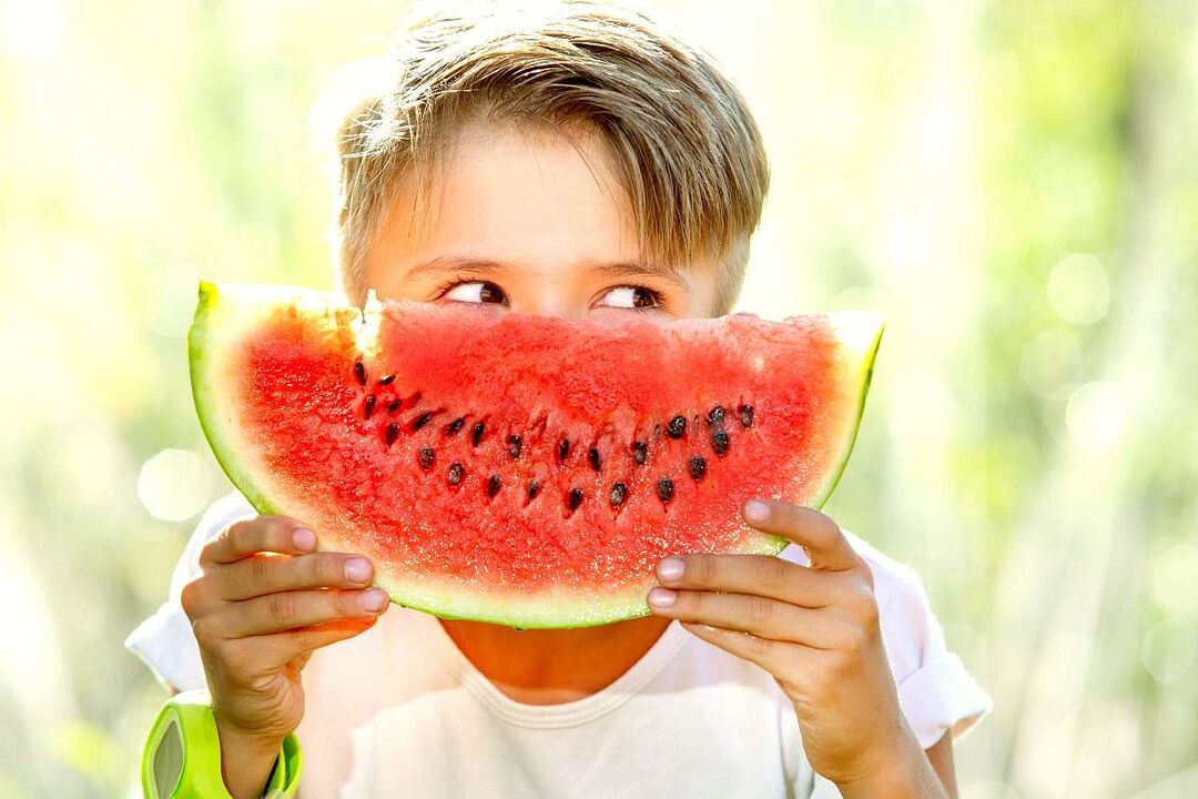 criança come melancia